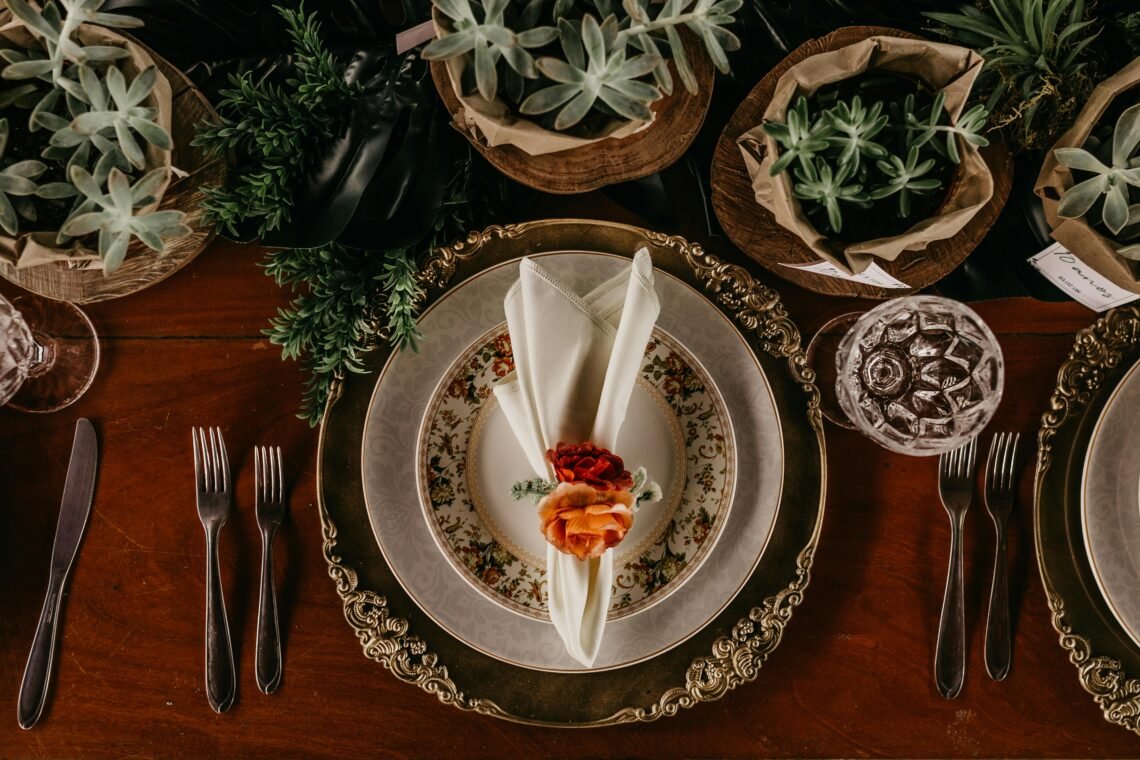 A beautifully arranged dining table with ornate plates, cutlery, and succulents for a sophisticated vibe.